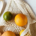 Bio-derived Polymers - Assorted citrus fruits in cotton sack on white surface