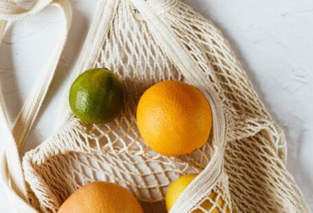 Bio-derived Polymers - Assorted citrus fruits in cotton sack on white surface