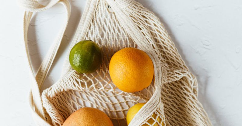 Bio-derived Polymers - Assorted citrus fruits in cotton sack on white surface