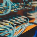 Adaptive Control - Closeup of many cables with blue wires plugged in modern switch with similar adapters on blurred background in modern studio