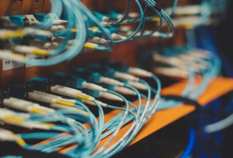 Adaptive Control - Closeup of many cables with blue wires plugged in modern switch with similar adapters on blurred background in modern studio