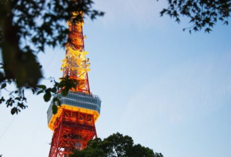 Electromagnetic Interference - From below of colorful high metal television tower with observation deck near tree branches in Tokyo
