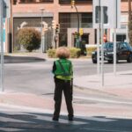 Beginner's Guide - A person standing on a street corner with a green jacket