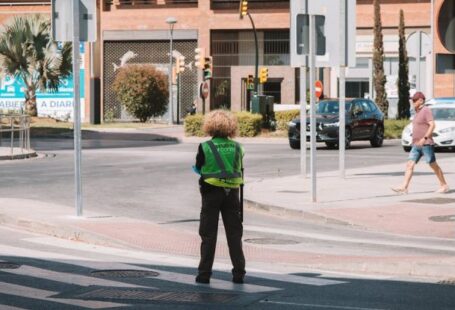 Beginner's Guide - A person standing on a street corner with a green jacket