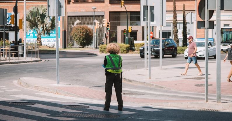 Beginner's Guide - A person standing on a street corner with a green jacket