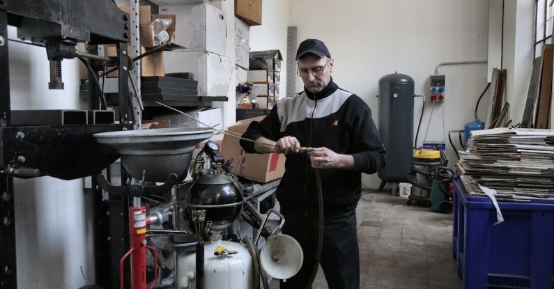 Troubleshoot - Focused mechanic repairing compressor hose in workshop